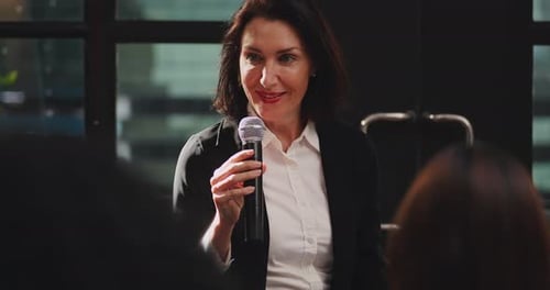 Professional Woman Speaking Into Microphone at Corporate Event