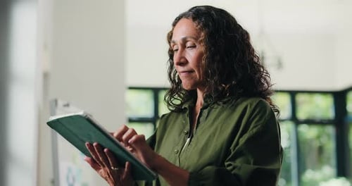 Creative, woman and reading with tablet in office for research, proofreading and update draft