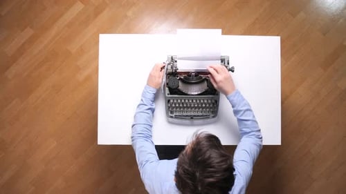 Man Frustrated with Typewriter Crumbles Paper, Overhead Shot