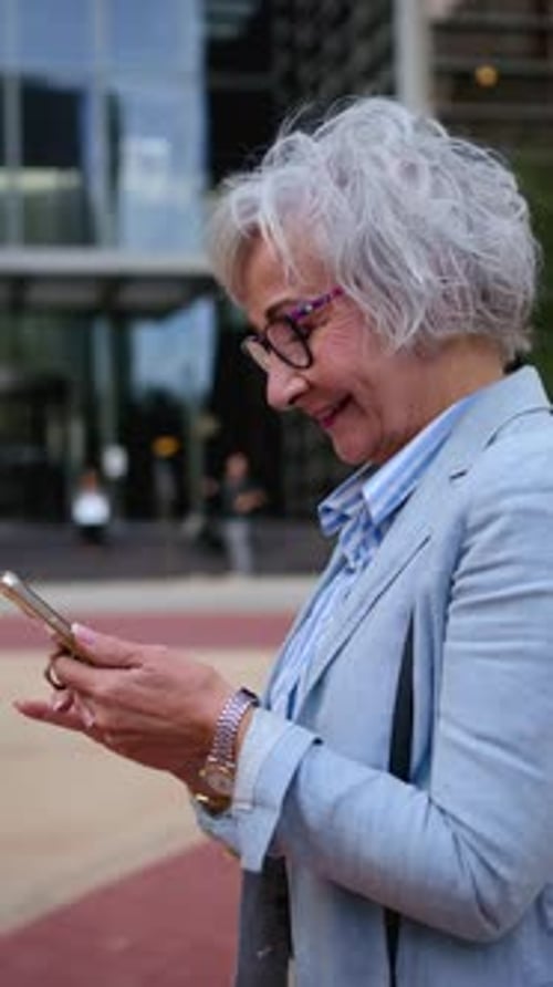 Side View Adult Caucasian Business Woman Walking Using Cell Phone Addicted Technology on Office Way