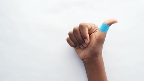 Hand with Blue Bandage on Thumb
