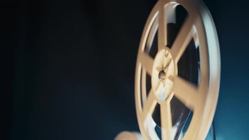 Spinning Film Projector Reel Against Dark Background
