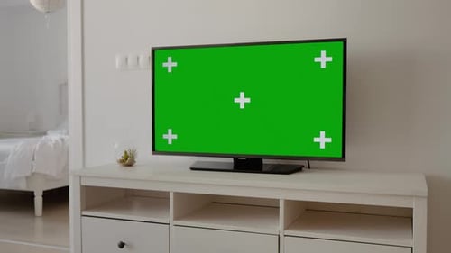 Chroma Key flat green screen tv monitor on stand in the living room.