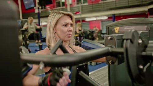 Woman Works Out on Lat Pulldown Machine at Gym