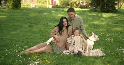 Family Anticipates New Baby in Sunny Green Park