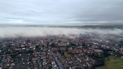 Decending Morning misty winter urban aerial scene. Drone footage. Showing drifting low clouds busy s