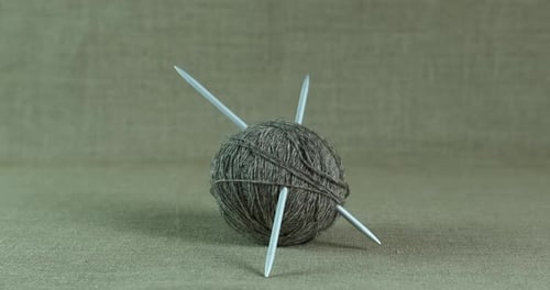 Gray Yarn Ball with Knitting Needles