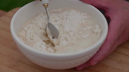 Kneading Dough in a White Plate Making Dough Against the Background of a Table