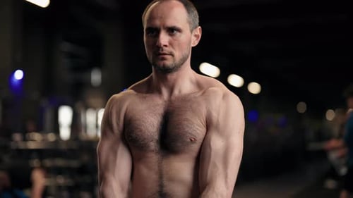 Strong Athletic Man Lifting Weights During Workout Session in Gym