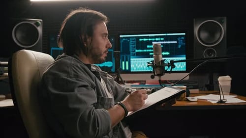 Caucasian Male Podcast Host Working on Content Plan in Studio