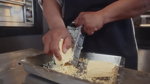Sous Chef Grating Cheese at Restaurant Kitchen