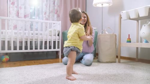 Baby Learning to Walk with Encouraging Mother