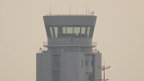 Der Kontrollturm des Flughafens überwacht den geschäftigen Flugverkehr bei Sonnenaufgang