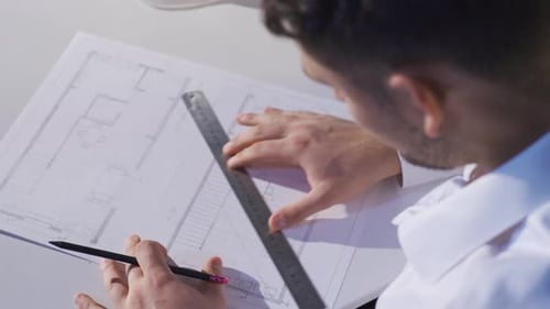 Der Ingenieur arbeitet mit Hilfe eines Lineals an architektonischen Zeichnungen.