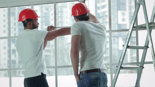 Zwei Arbeiter messen Fenster und reparieren