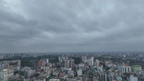 Overhead drone shot of dense city under cloudy sky