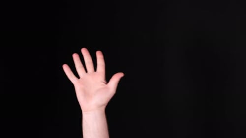 Hand Waving Against Black Background