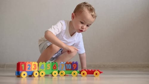 Little Boy Playing with Colorful Toy Train