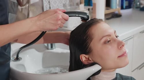 Handheld Shower Rinse Closeup Woman Reclining in Basin While Stylist Sprays Warm Water Over Hair