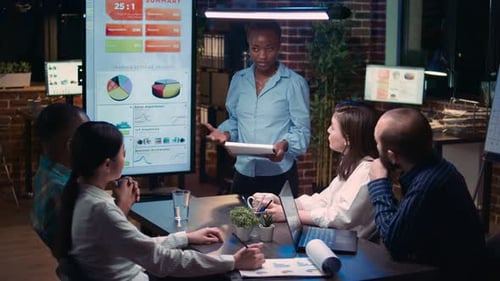 Diverse Team Discusses Analytics During Late Night Meeting