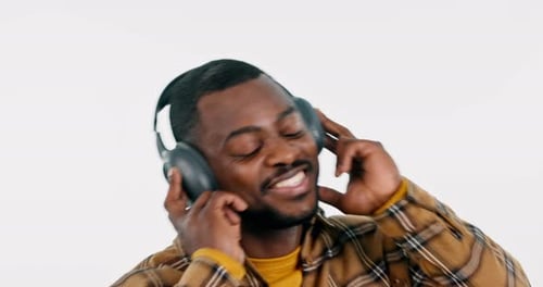 Headphones, dancing or happy black man listening to music for freedom in studio on white background