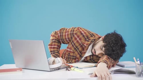 A university student who is bored with studying is getting bored and dropping his head.