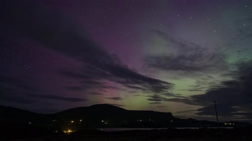 Timelapse of northern lights or Aurora Borealis dancing over thin layer of clouds, Skye, Scotland