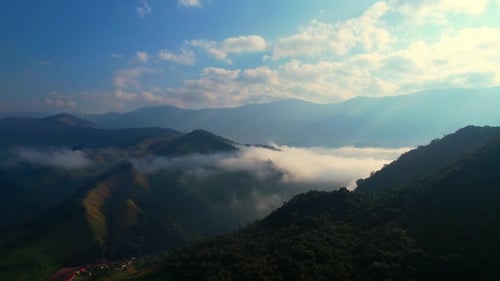 Aerial view over heavy fog in a tropical forest at sunrise