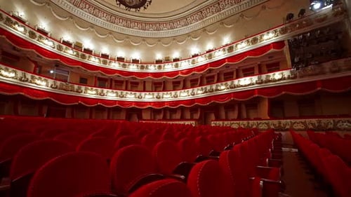 Theatrical hall with no people. Large auditorium with comfortable red chairs of a classical theater.