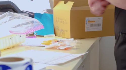 Hands Reviewing Medical Paperwork Near Syringes