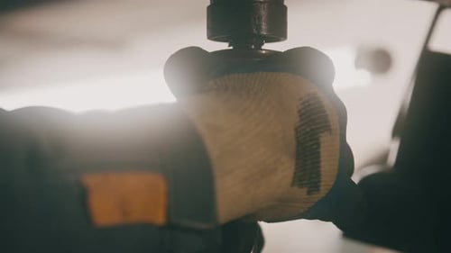 Nahaufnahme der Hände eines Arbeiters beim Entfernen eines Bohrers aus einer Bohrmaschine