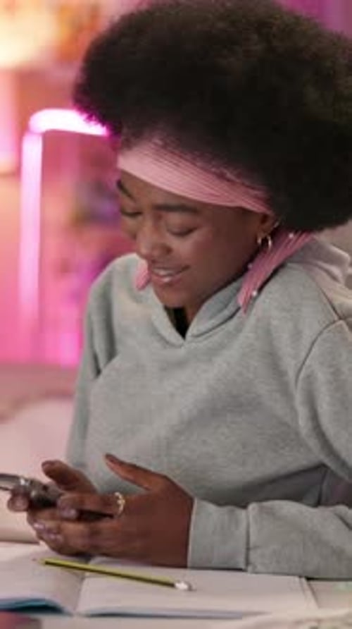 Teen Using Mobile Phone at Desk in Neon Room