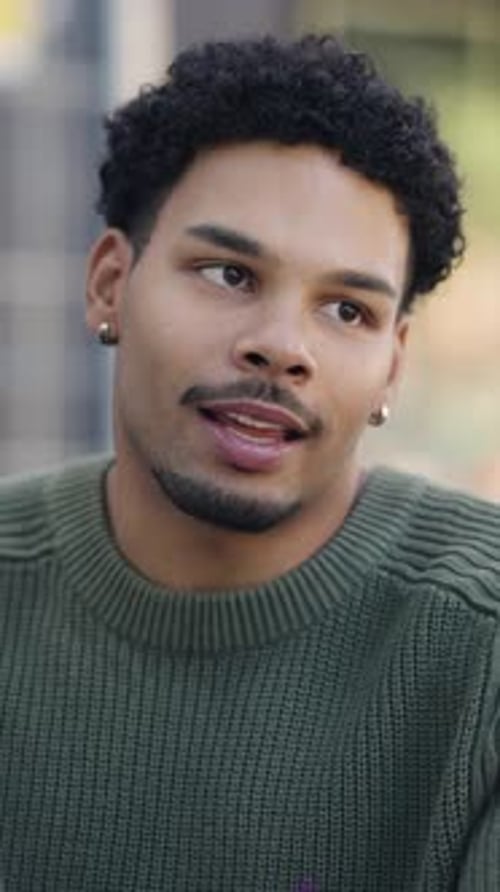 Junger afroamerikanischer Student spricht mit Freunden auf dem Campus Vertical