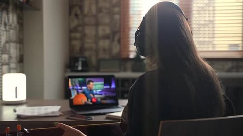 Mujer tomando clases de música en línea en Cozy Home