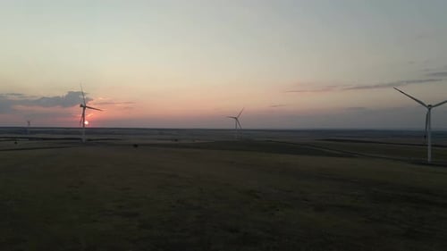 Windmills Generating Electric Power at Sunset in a Serene Windfarm Showcasing Green Energy