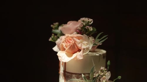 Close up to the top of an elegant multi-tiered wedding cake, with beautiful and delicate roses place