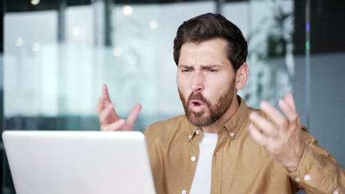 Angry Man Yelling at Computer in Office