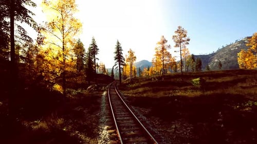 Trilha de trem colorida que se estende em direção à cena do nascer do sol na montanha