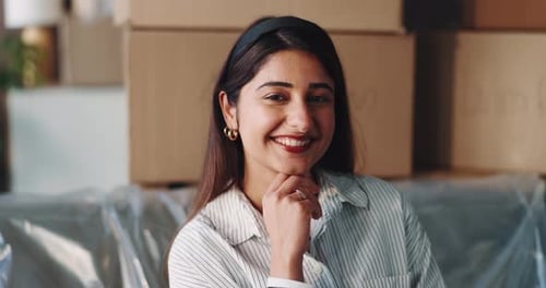Smiling woman with boxes in background at home