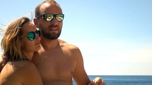 Couple enjoys a carefree summer sailing trip together on a beautiful ocean yacht