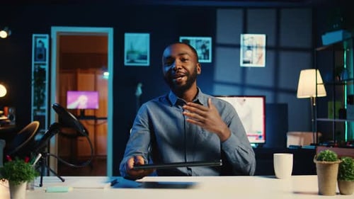 Man Reviews Laptop at His Desk