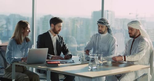 Male and Female Corporate Managers Talking on Business Interview with Muslim Investors Inside Office
