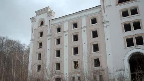 Das hohe, verfallene Gebäude mit vielen leeren Fensterrahmen in Spektralform kann beobachtet werden