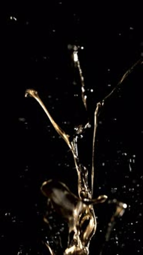 Golden Liquid Splashing Upwards in Slow Motion