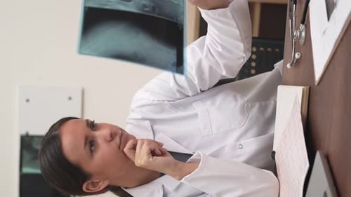 Female Doctor Examines X-ray in Office Setting