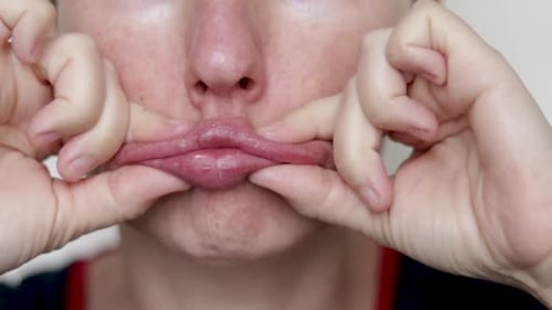Close-Up of Woman Stretching Mouth