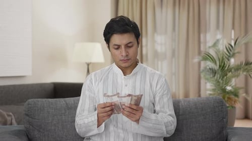 Young Adult Counting Money Indoors