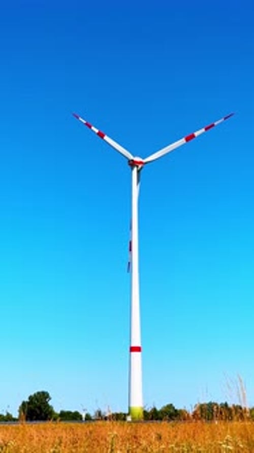 Single wind turbine rotating in the field. One wind mill producing renewable energy