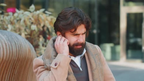 Indian Young Business Man Suffers From Earache Ear Pain Infection Inflammation on City Street