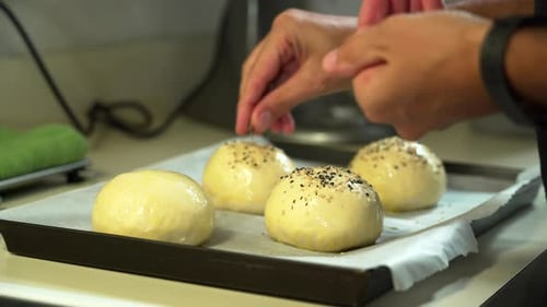 Topping Dough Balls with Sesame Seeds